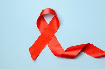 Eine rote Schleife auf blauem Hintergrund. Aids Awareness Ribbon